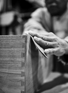 black and white photograph of hands on wood