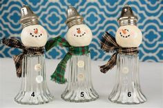 three glass snowmen with hats and scarves on their heads