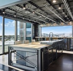 a kitchen with an island in the middle of it and lots of windows on both sides