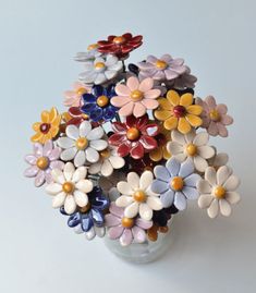 a vase filled with lots of different colored flowers