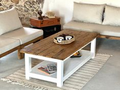 a living room with two couches and a coffee table in front of a stone wall