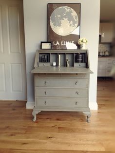 a white dresser with pictures on top of it