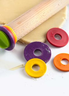 the dough is ready to be made with wooden rolling pins and colorful plastic rings on it