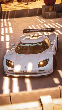 a white sports car driving down a street