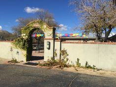 an entrance to a building with a colorful train on it's roof and trees in the background