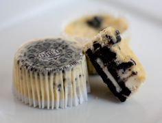 an oreo cookie is cut in half on a white plate next to a cupcake