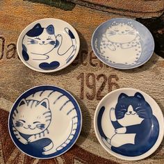 four blue and white plates with cats on them