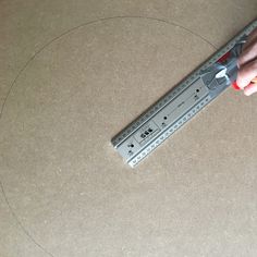 a person holding a large ruler in their right hand and pointing it at the center