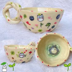 three ceramic bowls with designs on them sitting on a white tablecloth next to each other