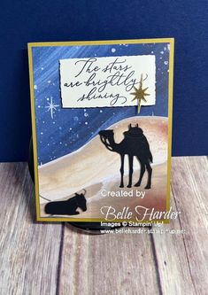 a handmade card with a camel and a star on the sky in front of a blue background