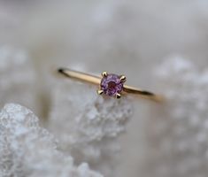 a close up of a ring with a pink stone