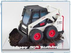 a birthday cake made to look like a bulldozer on top of some dirt