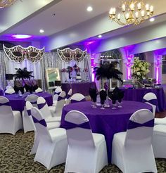 the banquet room is decorated with purple and white linens