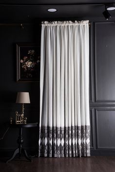 a black and white room with curtains hanging on the wall