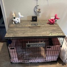 a dog kennel with some stuffed animals on it's top and the door open