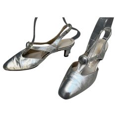 Beautiful & rare Balenciaga silver leather slingback kitten heels. Cut-out vamp with a decorative button at the center. Handmade leather. ★ An amazing piece of fashion history! Circa 1960s Balenciaga Custom Originals Marked Size 7 Leather Silver Great Condition. Light scuff marks on the inside of the right foot. Small crack in the leather on the inside of the left strap that is reinforced by the interior leather. These imperfections do not distract; shoes present beautifully, are sturdy and well 1960s Balenciaga, Vintage Balenciaga, Slingback Kitten Heels, Cristobal Balenciaga, Low Heel Shoes, Silver Heels, Leather Silver, Pretty Shoes, Fashion History