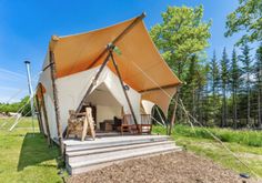 a tent set up in the middle of a field with steps leading up to it