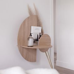 a wooden shelf with various items on it and a white wall in the back ground