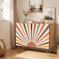 a wooden cabinet with an abstract design painted on the front and sides, in a living room