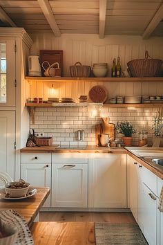 a kitchen filled with lots of white cabinets and counter top space next to a wooden table