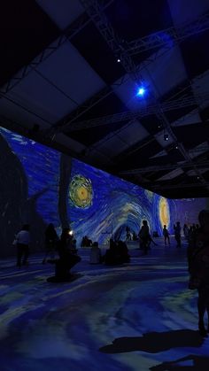 people are standing in an art gallery looking at the starry painting on the wall