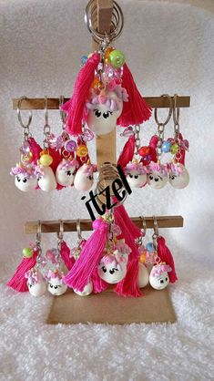 the key chain is hanging from the wooden stand with many charms on it's sides