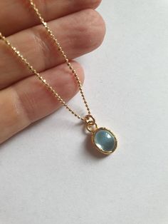 This minimalist Blue Topaz solid gold necklace was designed with a light blue December birthstone pendant, to beautifully accompany you through your busy days. The classic simple design is always pretty for day and evening, work or fun. The gold Blue Topaz necklace is handmade and delicate and available both with a 9kt or 14 karat pendant. The gold chain is made of 14k and available in a couple lengths. The clear Blue topaz necklace is a great birthstone necklace and a perfect chic and elegant g Elegant Blue Gold-plated Charm Necklace, Blue Birthstone Necklace In Gold Plated, Gift Gold Necklace With Blue Topaz, Delicate Oval Pendant Birthstone Necklaces, Delicate Oval Pendant Necklace With Birthstone, Delicate Oval Pendant Birthstone Necklace, Blue Round Pendant Necklace For May Birthstone, Blue May Birthstone Round Pendant Necklace, Blue Topaz Oval Pendant Necklace As Gift