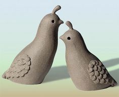 two clay birds standing next to each other