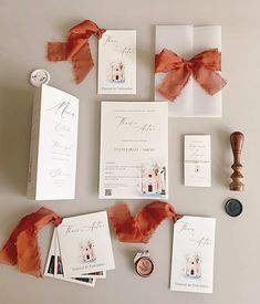 the wedding stationery is laid out on top of each other, including an orange ribbon