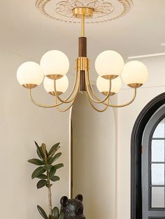 a chandelier hanging from the ceiling in a room with a potted plant