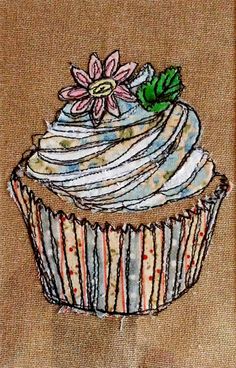 a cupcake with flowers on it is embroidered onto a piece of fabric that has been stitched together