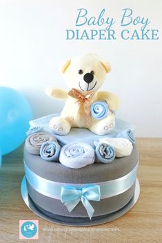 a baby boy diaper cake with a teddy bear on top