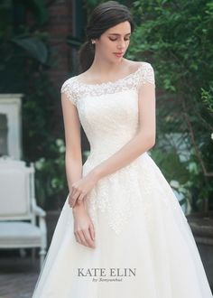 a woman in a white wedding dress is posing for the camera with her hand on her hip