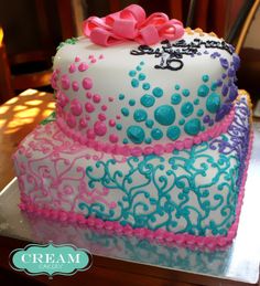 the cake is decorated with pink and blue icing