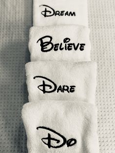 three white towels with black lettering on them that say, believe, dare and disney