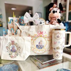 mickey mouse and other disney merchandise are on display in a store window, including a tote bag