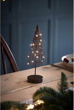 a small christmas tree is lit up on a table