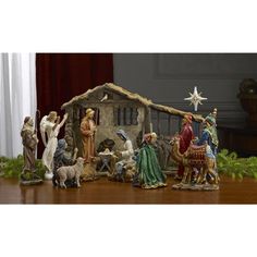 a nativity scene with figurines of people and animals in front of a house