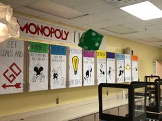 a classroom with posters on the wall and lights hanging from the ceiling in front of them