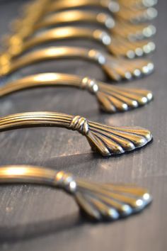 gold colored metal handles are lined up on a table