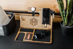 an electronic device is sitting on a table next to a potted plant and other items