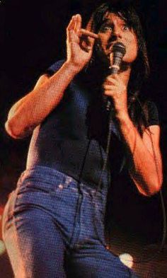 a woman singing into a microphone on stage