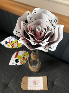 a paper flower sitting on top of a table next to a card holder and tag