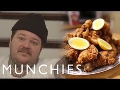 a man is standing in front of a plate of fried food with lemon slices on it