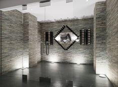 an empty room with several wine bottles on the wall and two mirrors in the middle