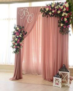 a wedding ceremony setup with pink drapes and flowers