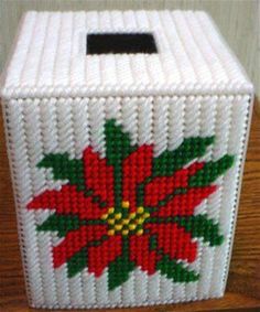 a knitted tissue box decorated with poinsettis