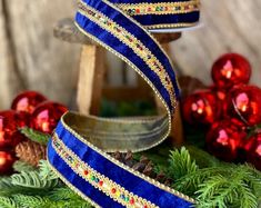 a blue and gold ribbon with christmas decorations in the background