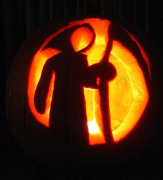 a carved pumpkin with an image of a man holding a staff