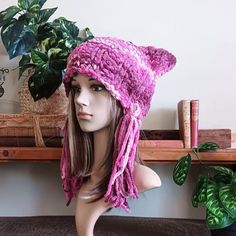 a mannequin head wearing a pink knitted hat with cat ears on it